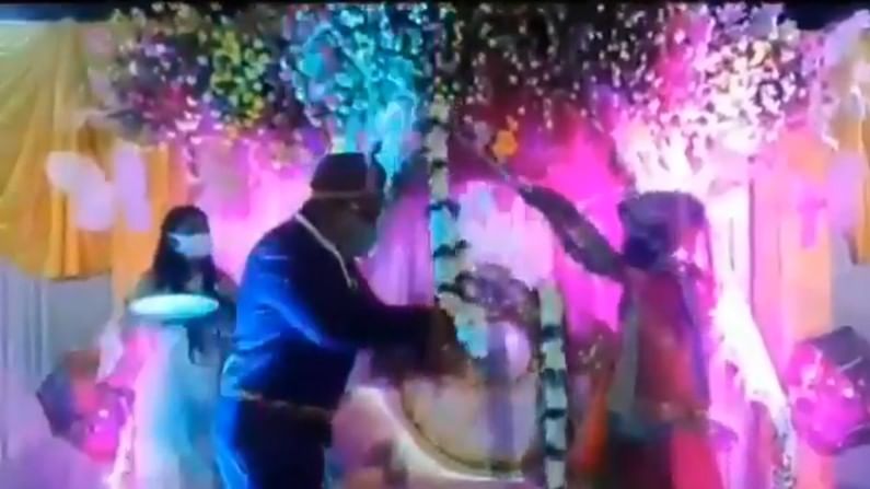 VIDEO : लग्नात कोरोनाची भीती, नवरदेव-नवरीने थेट काठीने वरमाला घातल्या