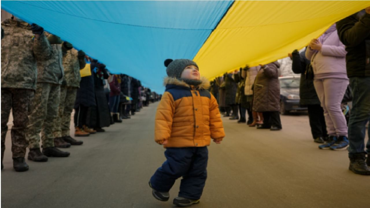 पूर्व यूक्रेनमध्ये लोकांनी यूनिटी मार्च काढला तो रशियाच्या धमक्यांच्या पार्श्वभूमीवर. त्यावेळी त्यांनी यूक्रेनचा हा ध्वज असा धारण केला होता. त्याच ध्वजाखाली चालणाऱ्या ह्या छोट्यानं जगाचं लक्ष वेधून घेतलं.