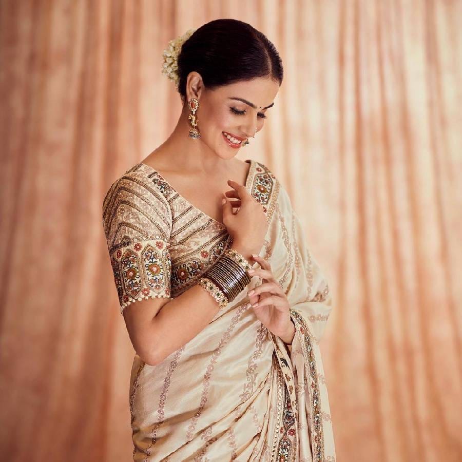 सोशल मीडियावर समोर आलेल्या फोटोंमध्ये अभिनेत्री जेनेलिया क्रीम रंगाच्या बॉर्डरच्या साडीत दिसत आहे. ब्लाउजवर तिचे जरीचे काम केले आहे.  साडीसोबतच तिने  सुंदर मेकअप केलाय तर केसांत आंबाडा घालत गजरा लावला आहे.
 