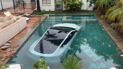 टेस्ला कार भिंत तोडून थेट स्वीमिंगपूलात बुडाली