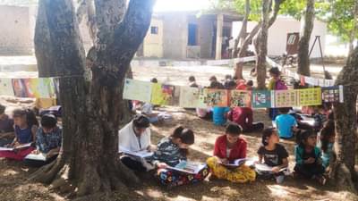 निसर्गात वाचनानंद काही वेगळाच!, झेडपीचे विद्यार्थी शाळा परिसरात लुटतात आनंद