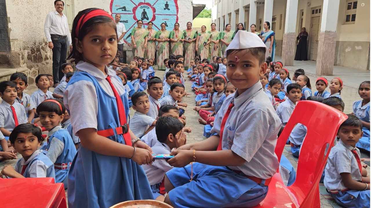 व्हायरल झालेल्या फोटोमध्ये एक विद्यार्थी एका विद्यार्थीनीला भेटवस्तू देत आहे. 