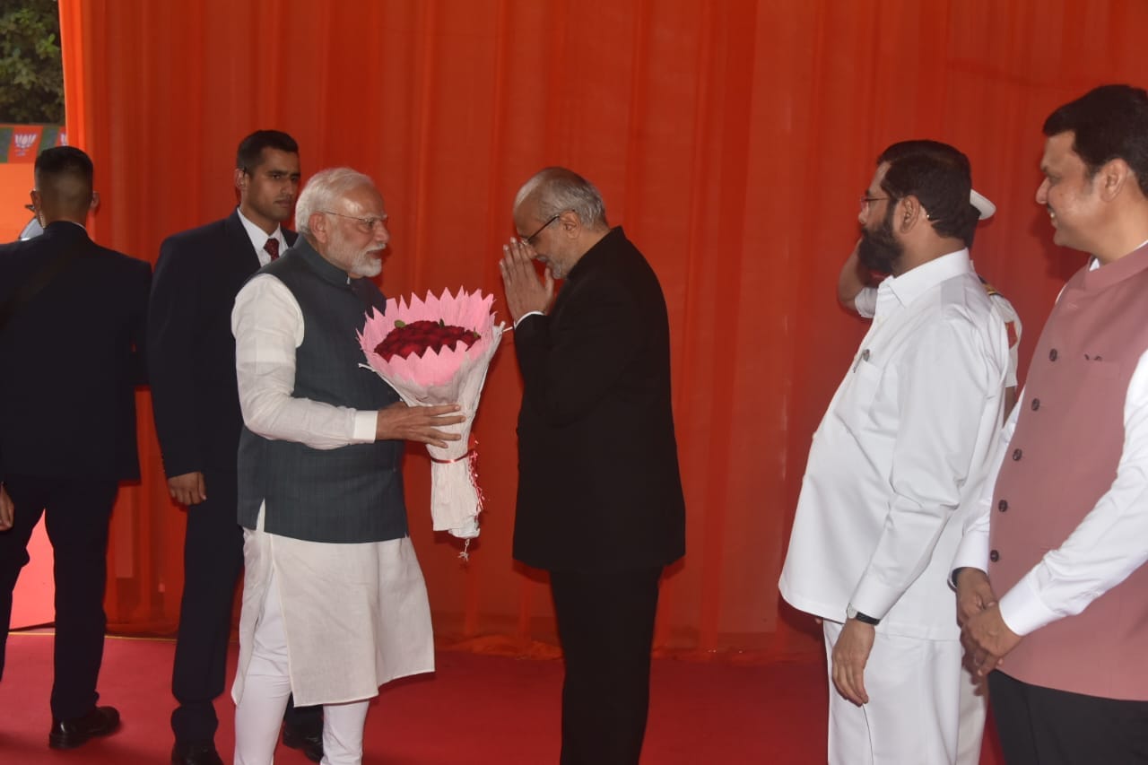  शपथविधी सुरु होण्यापूर्वी पंतप्रधान नरेंद्र मोदी यांचे राज्यपाल सी.पी.राधाकृष्णन यांनी पुष्पगुच्छ देऊन स्वागत केले, त्यावेळी छायाचित्रात देवेंद्र फ़डणवीस आणि  एकनाथ शिंदे दिसत आहेत. 