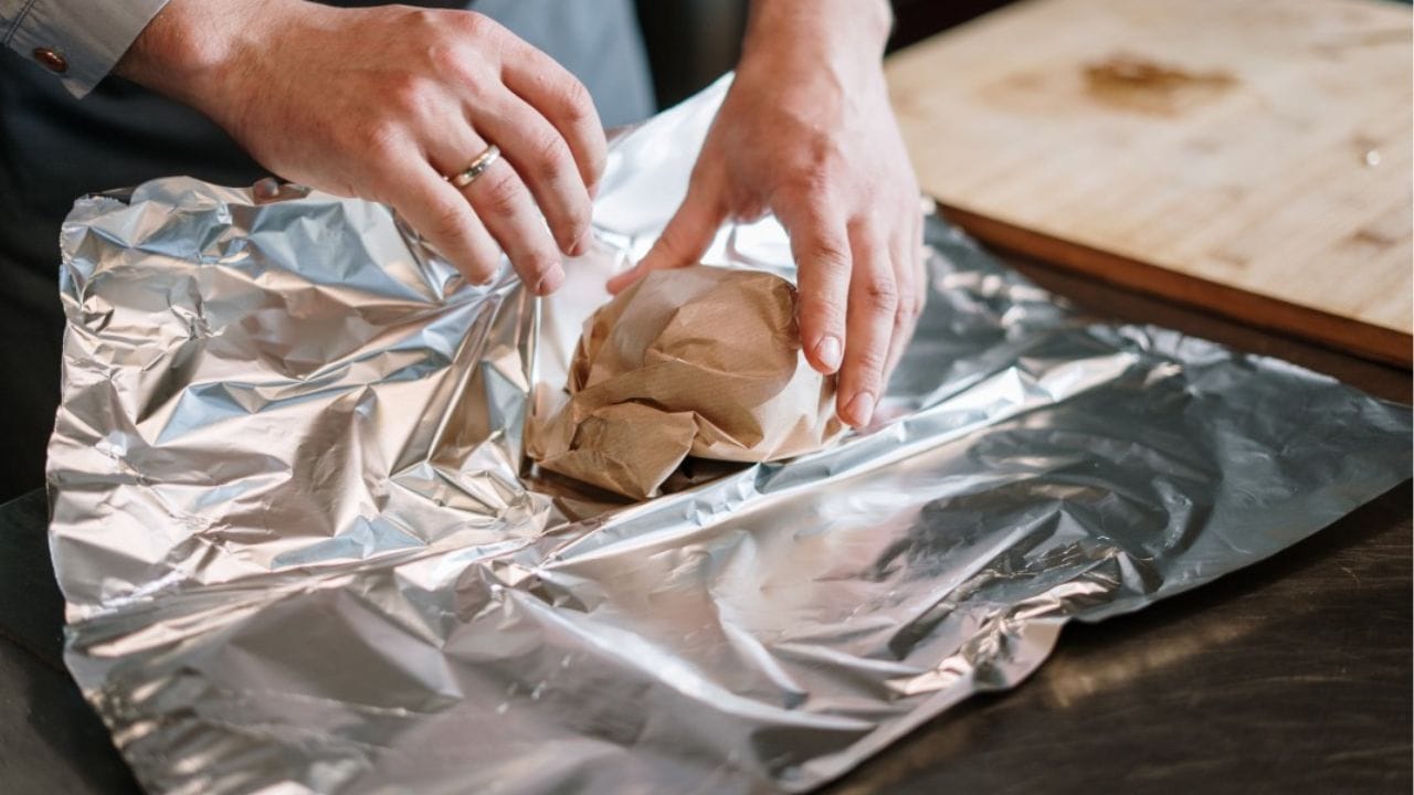 अॅल्युमिनियम फॉइल की बटर पेपर... अन्न पॅक करण्यासाठी कोणते योग्य? जाणून घ्या अॅल्युमिनियम फॉइल की बटर पेपर... अन्न पॅक करण्यासाठी कोणते योग्य? जाणून घ्या
