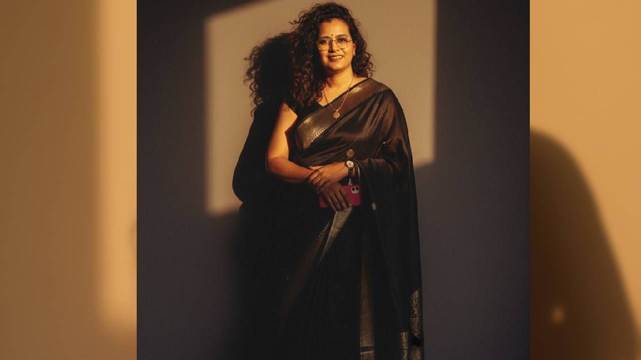 अनेकदा महिलांना काळा रंग आवडतो. जर तुम्हाला काळ्य साडीत रेट्रो लूकमधील फोटो तयार करायचा असेल तर Convert this person into a retro vintage grainy but bright image, black party-wear saree, 90s film aesthetic. She is standing against a solid, deep wall with dramatic shadows and contrast, creating a mysterious and artistic atmosphere. The environment feels windy and romanticised. Lighting is warm, with golden sunset tones evoking golden hour glow. The background is minimalist and slightly textured. Her expression is moody, calm, yet subtly happy and introspective हे प्रॉम्प्ट द्या.