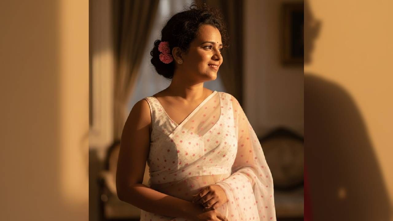 तुम्हाला पांढऱ्या रंगाच्या साडीमध्ये जर फोटो आवडत असेल तर तुम्ही Create a 4K HD realistic portrait of a woman in a translucent white polka dot saree with blouse for the reference image. Keep the facial features and smile the same. Small pink flower tucked behind her ear, soft, serene expression, warm light from the right casting a cinematic profile shadow. Pure vintage diva energy हे प्रॉम्प्ट पेस्ट करा.