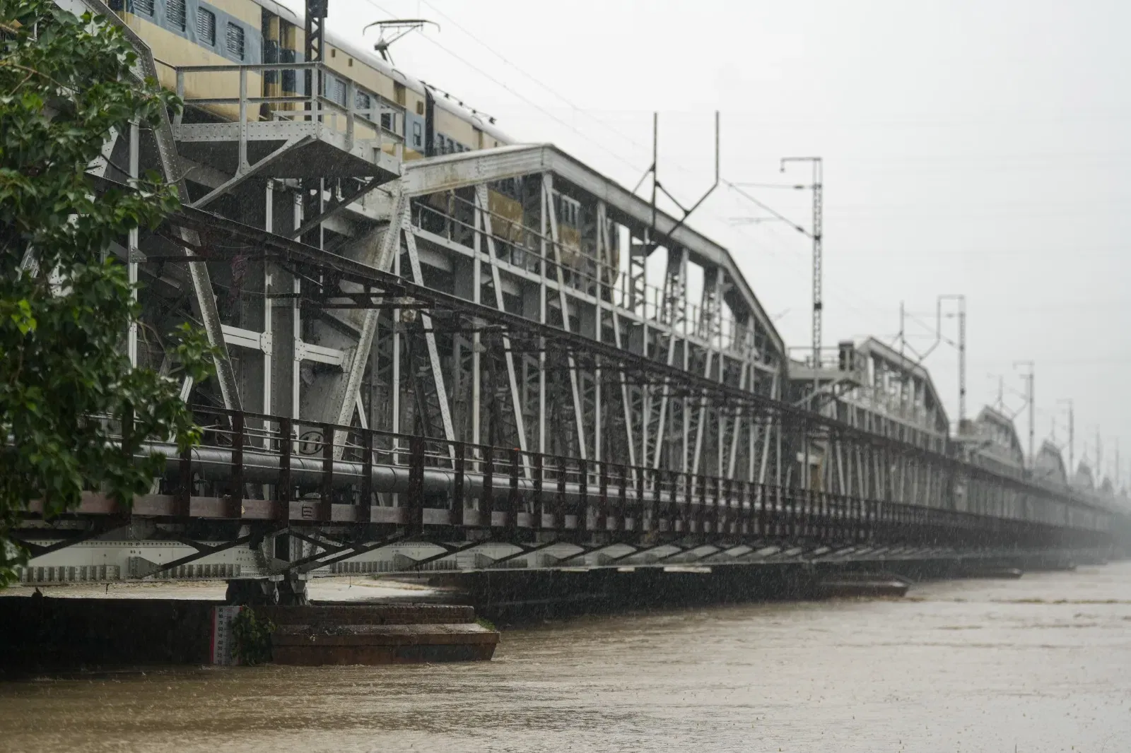 यमुना नदीच्या पाणी पातळीत वाढ झाल्याने जुन्या दिल्लीतील रेल्वे पुलावरील रेल्वे वाहतूक थांबवण्यात आली आहे. मंगळवारी सायंकाळी 5 वाजल्यापासून वाहनांची वाहतूक थांबवली, तसेच बुधवारी सकाळी 6.20 पासून रेल्वे वाहतूक थांबवली आहे. फोटो-PTI)