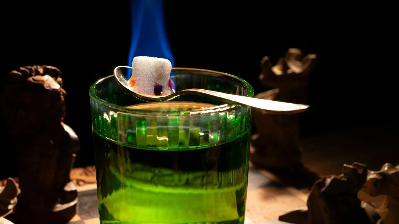 वाइन एक्सपर्ट सोनल हॉलंड सांगतात, ही ड्रिंक इतकी स्ट्रॉन्ग असते की थेट पिणं शक्यच नाही. त्यामुळे ग्लासामध्ये एक खास चमच्यावर साखरेचा तुकडा ठेवला जातो, त्यावर थंड पाणी हळूहळू ओतलं जातं. पाणी मिसळल्यावर ड्रिंकचा रंग दूधासारखा पांढरा होतो. या संपूर्ण प्रक्रियेला “लाऊझिंग” (Louching) म्हणतात. याच्याशिवाय हे ड्रिंग पिणे शक्यच नाही. त्यामध्ये अल्कोहॉलचे प्रमाण जास्त असल्यामुळे त्याता पाणी आणि साखर घालणे गरजेचे असते.