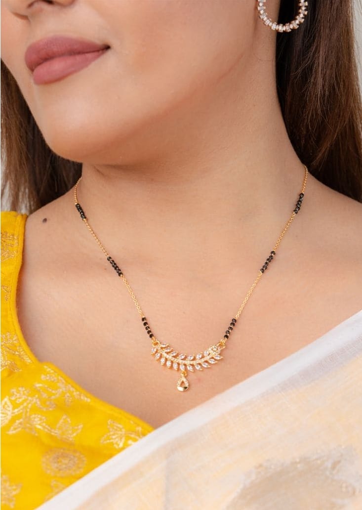 लीफवाले एलिगेंट पेंडेंट - लीफ शेपमध्ये सुंदर स्टोन वर्कसोबत हे मंगळसूत्र खूप एलिगेंट लुक देते. हे थोडे हेव्ही लूक देखील देते. यामुळे सणासुदीत आणि खास क्षणांच्या वेळी हे परिधान करण्यासाठी बेस्ट आहे. पातळी गोल्ड चेनसोबत काळ्या मोत्यांचा वापर खुपच सुंदर दिसतो. 